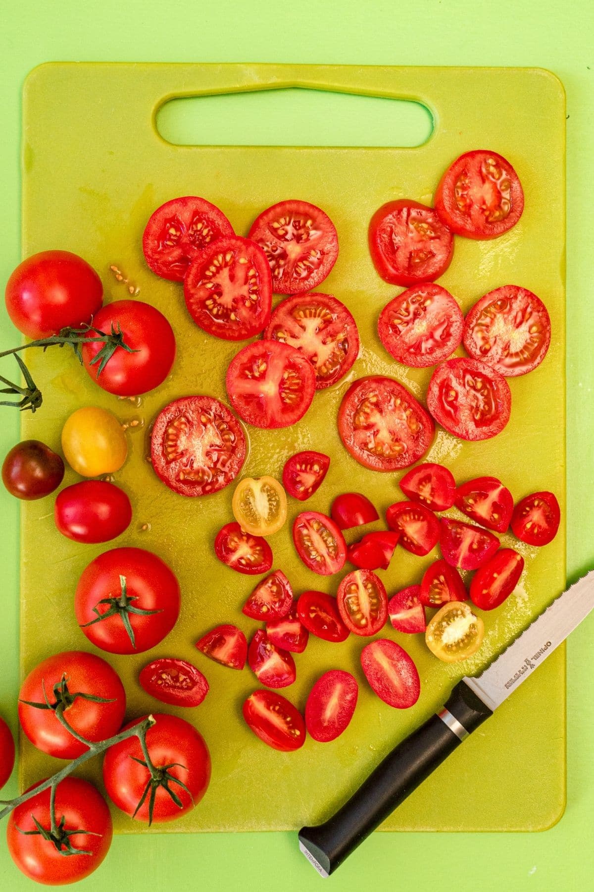 Sliced tomatoes on a green cutting board