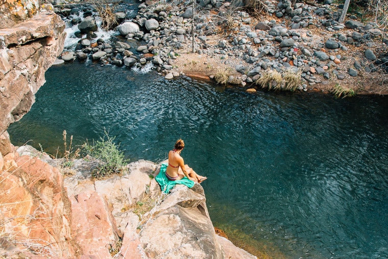 Megan sitting on a rock looking down at the swimming hole at grasshopper point