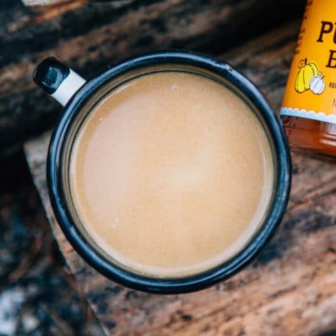 Pumpkin chai in a mug on a wood log