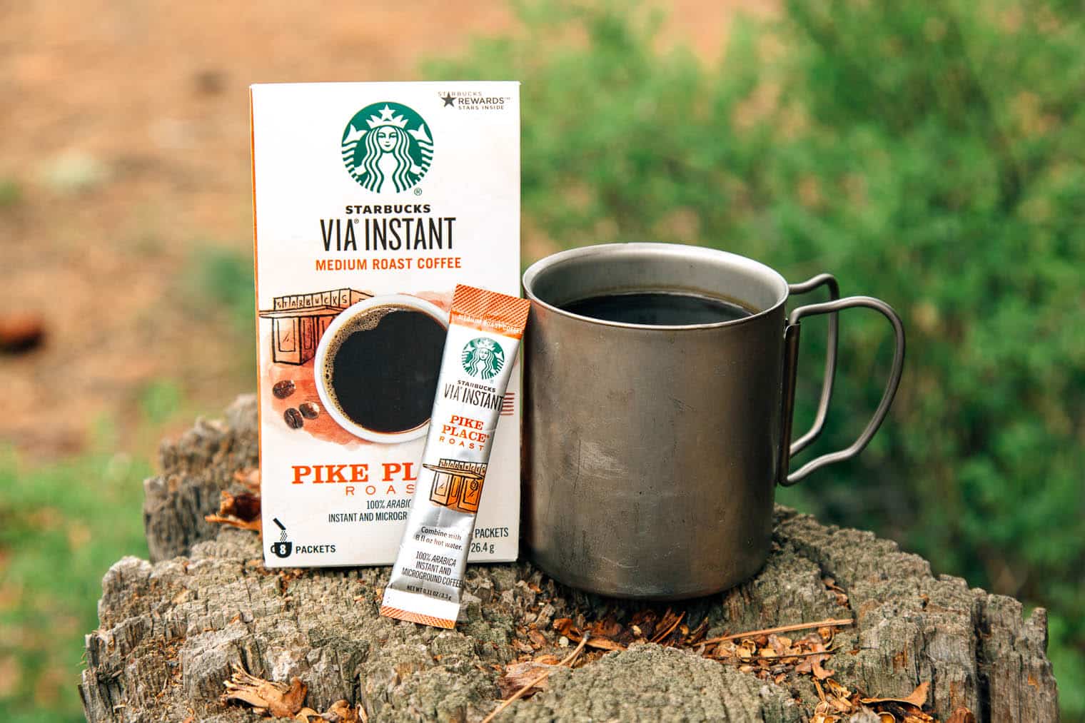 Starbucks Via instant coffee packaging next to a camp mug