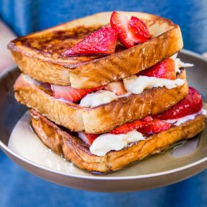 Michael holding a plate of stuffed french toast topped with strawberries