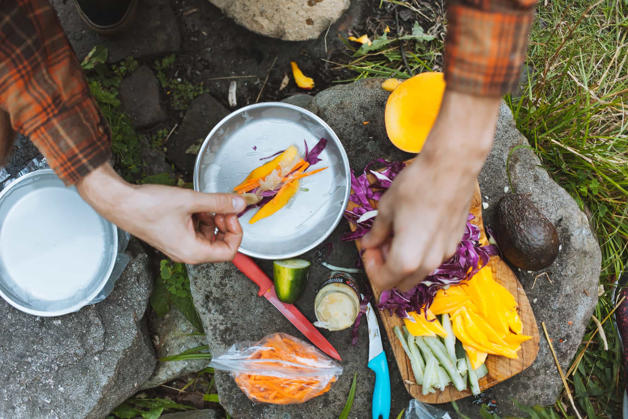 Hands assembling a fresh spring roll