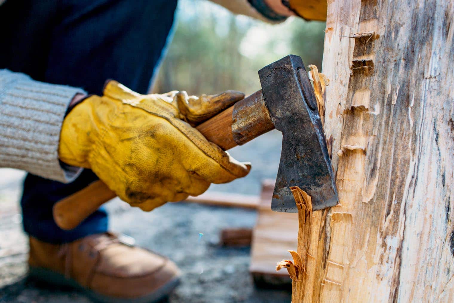 Michael using a small hatchet to rough up the edges of a Swedish firelog