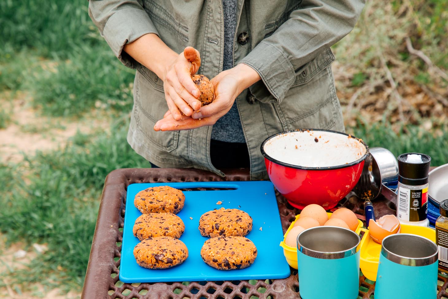 Megan is forming black bean burger patties at a camping table.