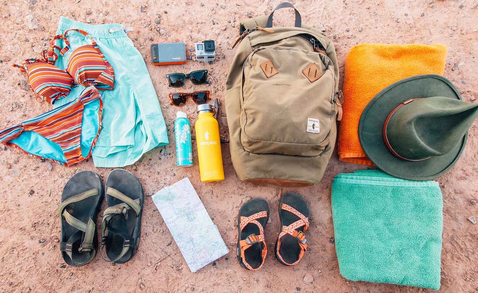 Gear for a swimming hole hike laid out on the ground