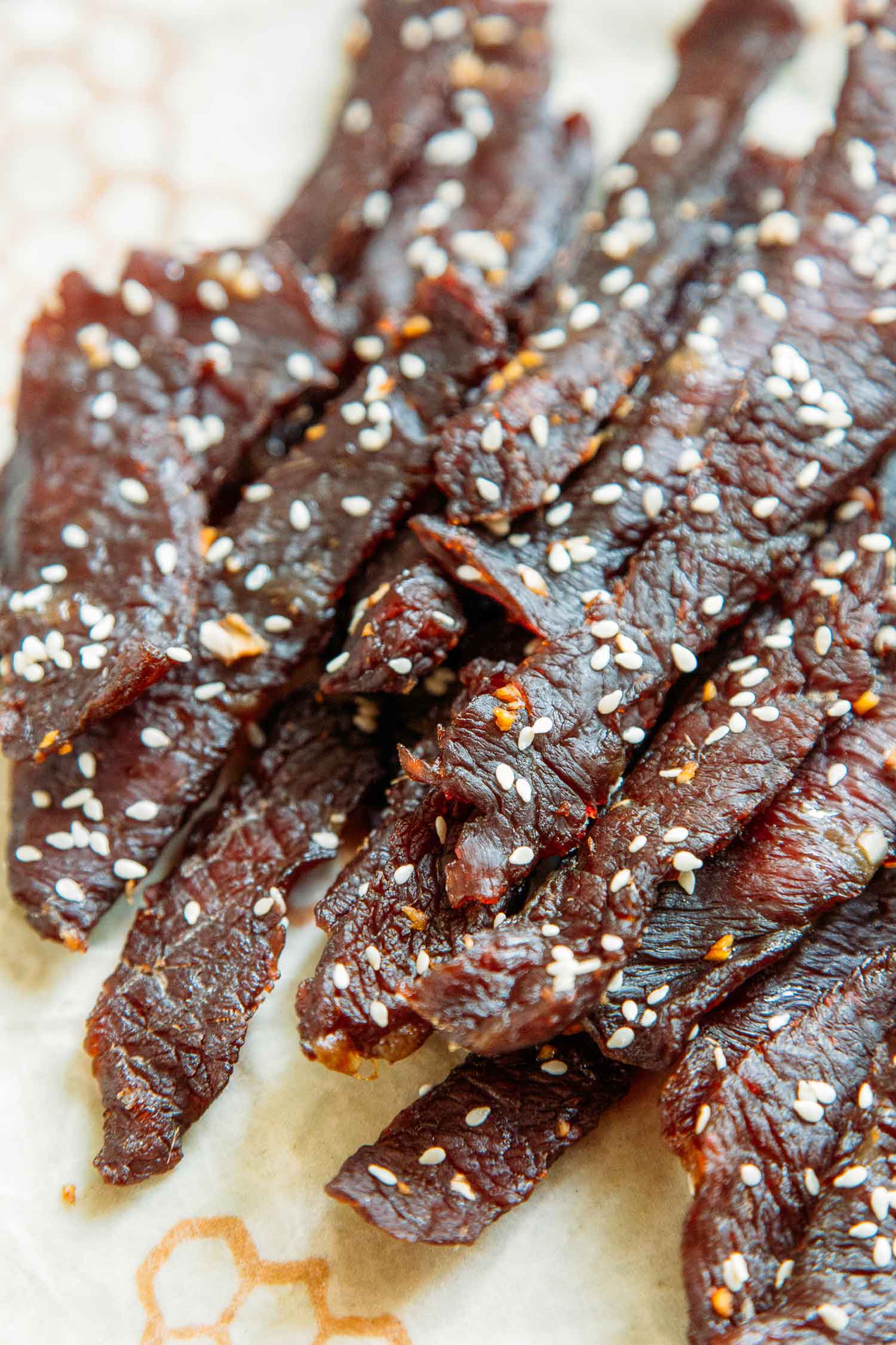 Overhead view of teriyaki beef jerky stacked on a napkin.