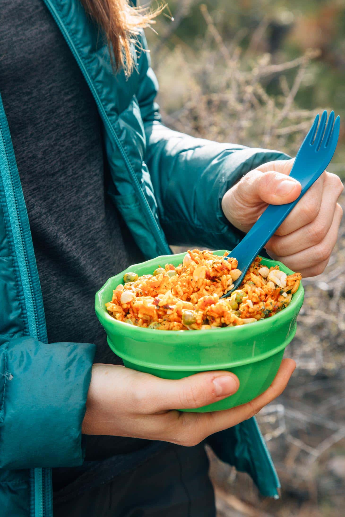 Woman holding a green bowl of Thai red curry rice