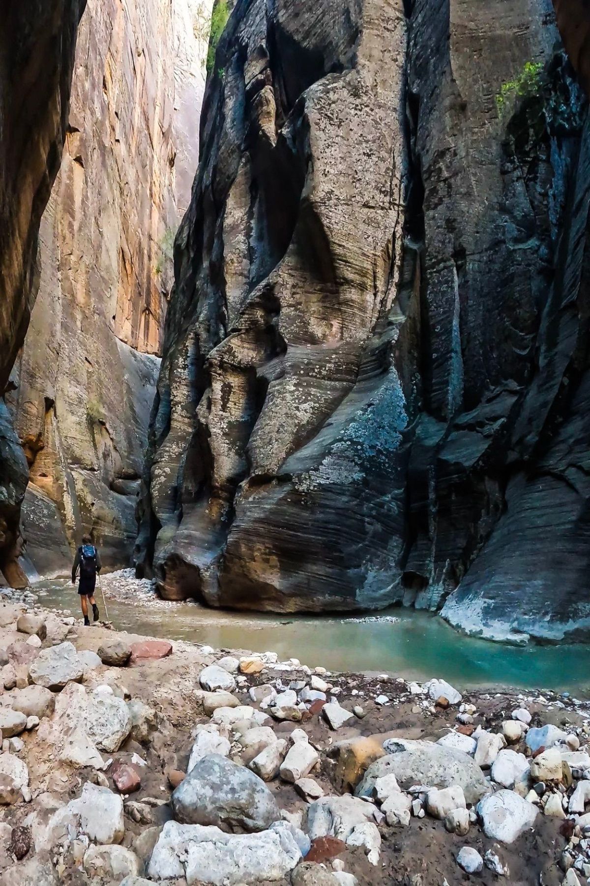 A man hiking between narrow canyon walls