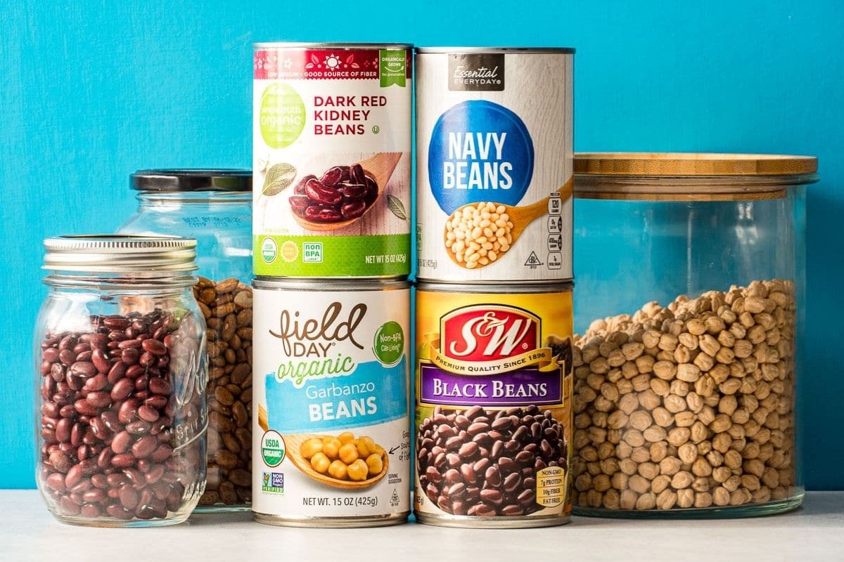 Canned beans stacked in front of a blue background