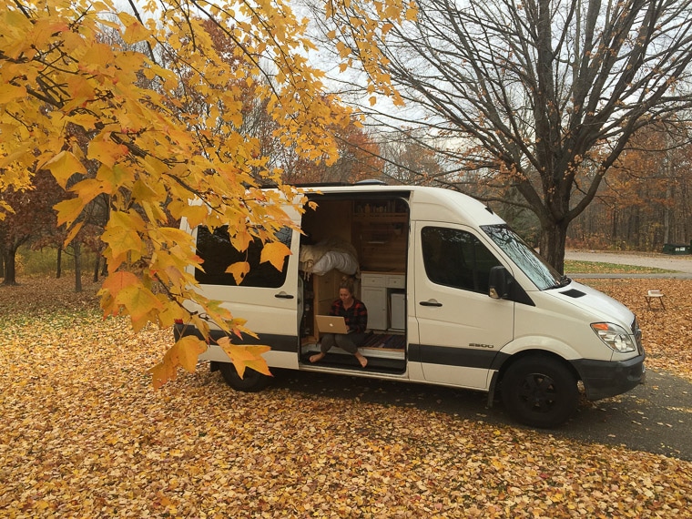 A woman sitting in a sprinter camper van