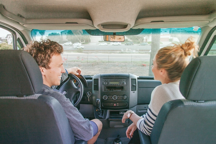 A man and woman sitting in the cab of a van