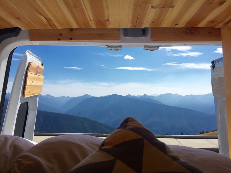 A view of the mountains as seen through the back doors of a camper van