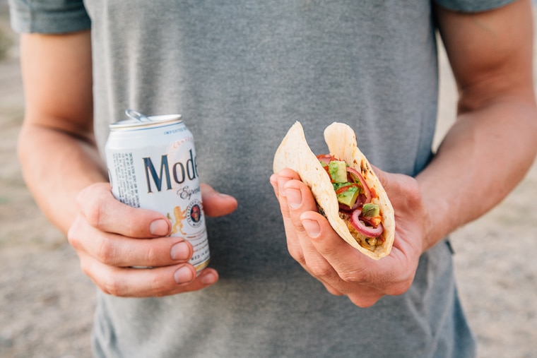 Michael holding a taco and a beer