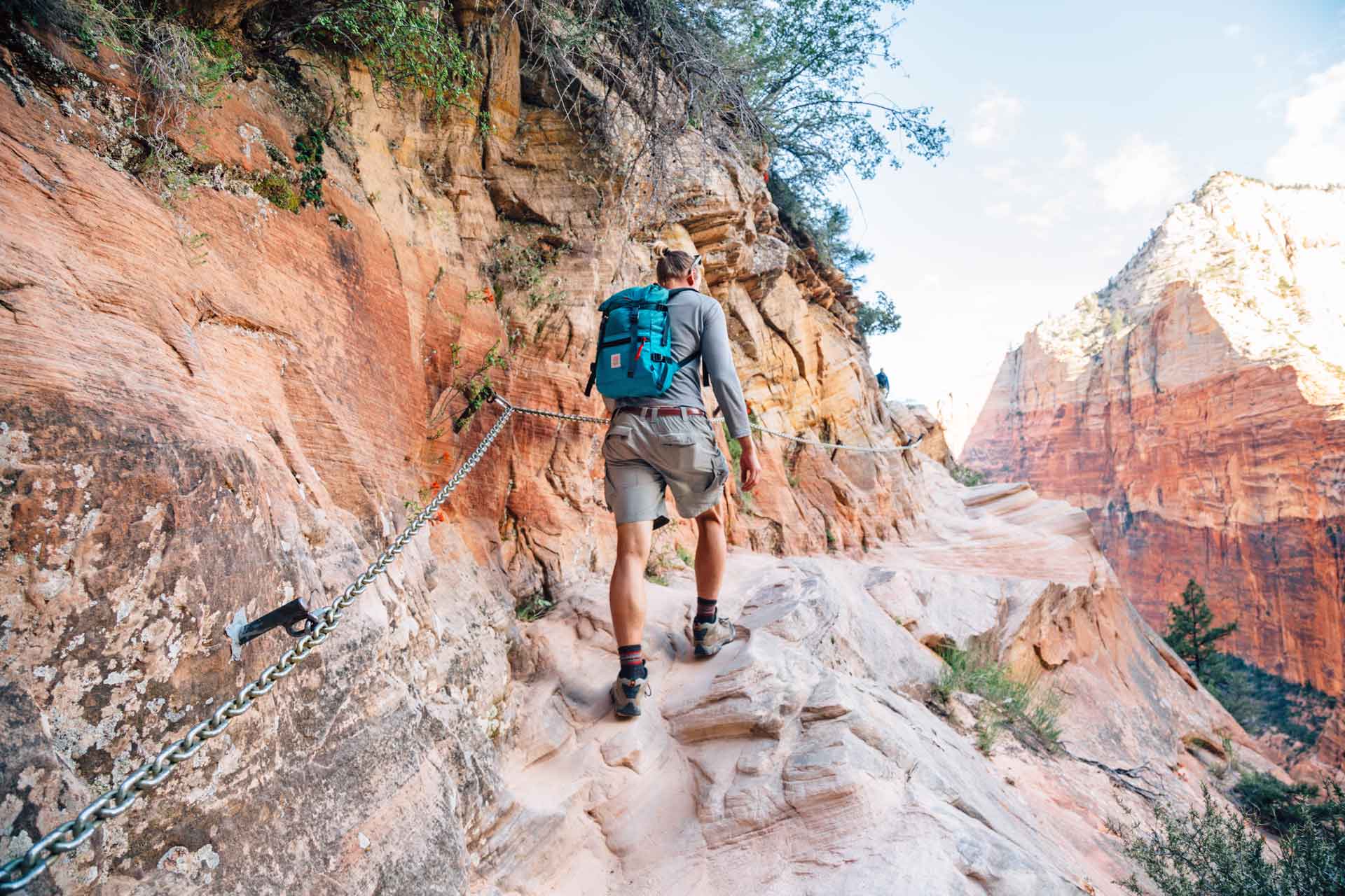 Michael using a chain handrail while hiking to hidden Canyon