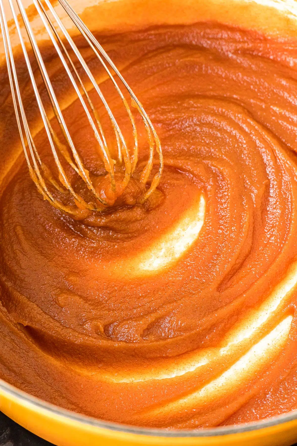 Whisking apple butter in a large pot.