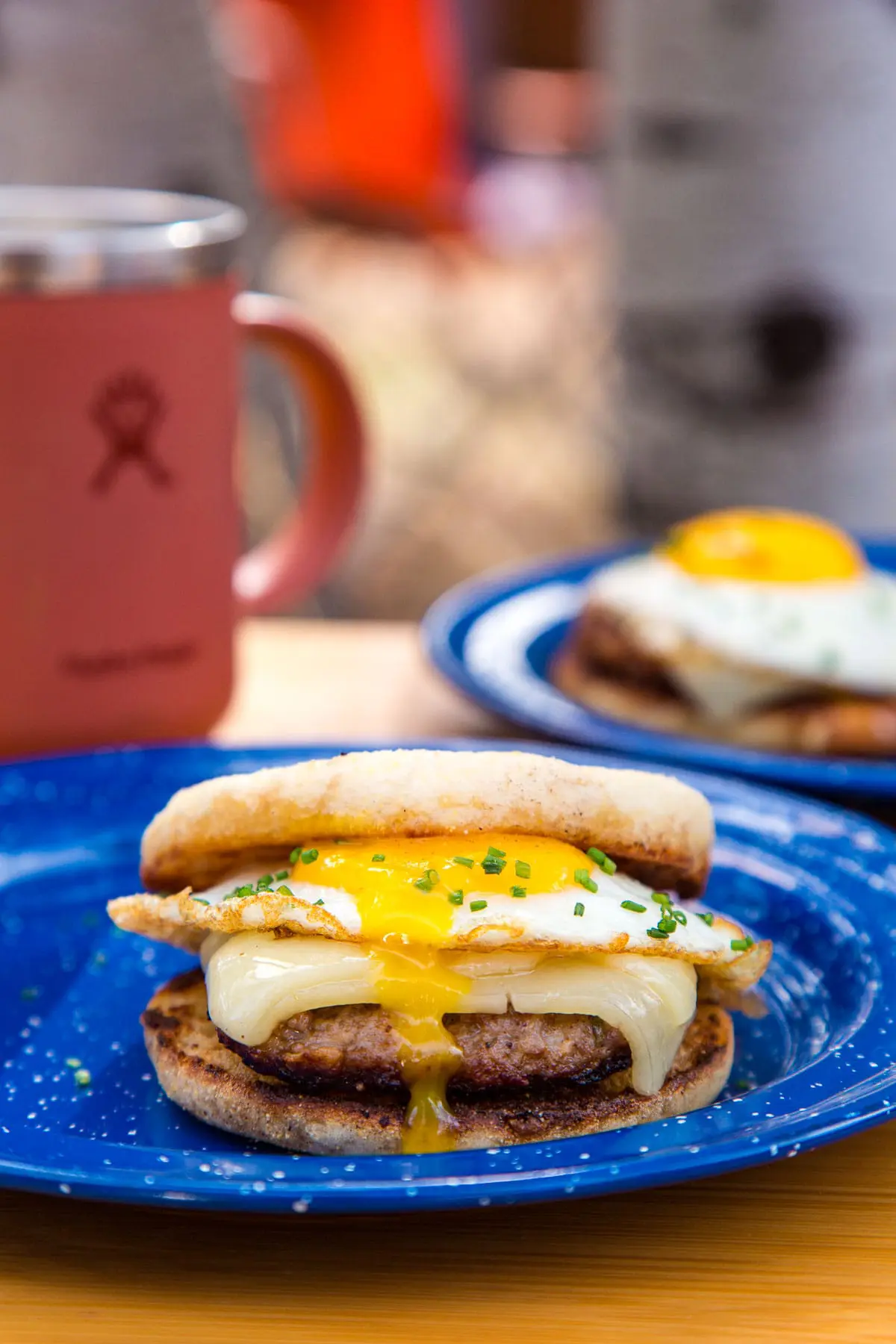 Side view of a sausage and egg sandwich with a runny yolk.