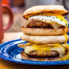 Side view of two sausage and egg sandwiches with runny yolks.