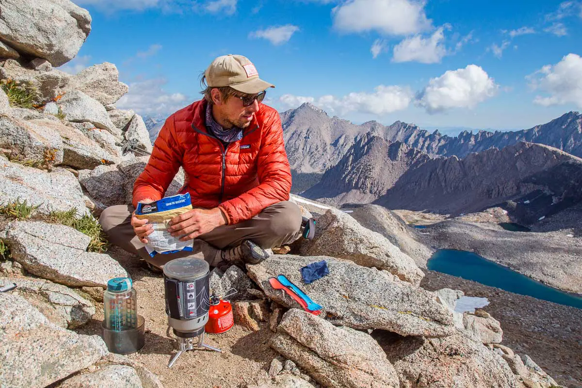 Michael sitting at the top of a mountain pass eating lunch