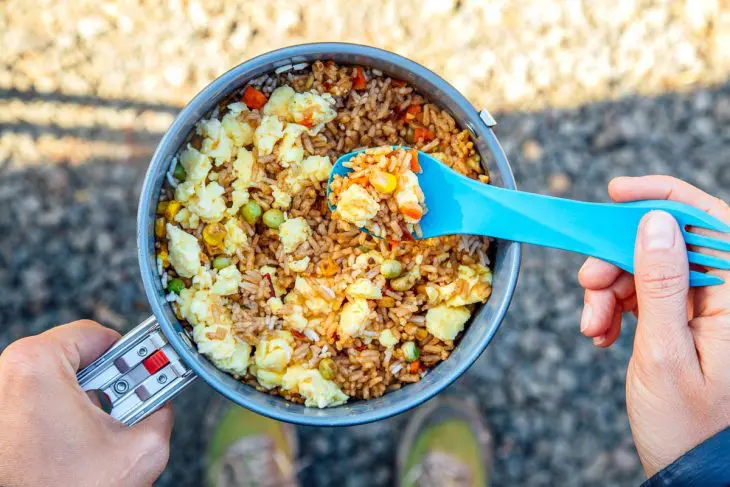 Megan holding backpacking fried rice in a pot