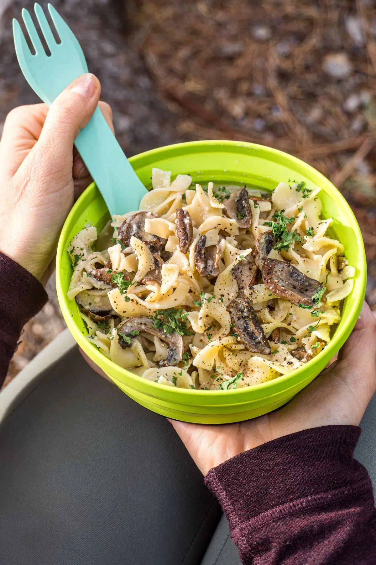 Megan's hands holding a bowl of dehydrated mushroom stroganoff