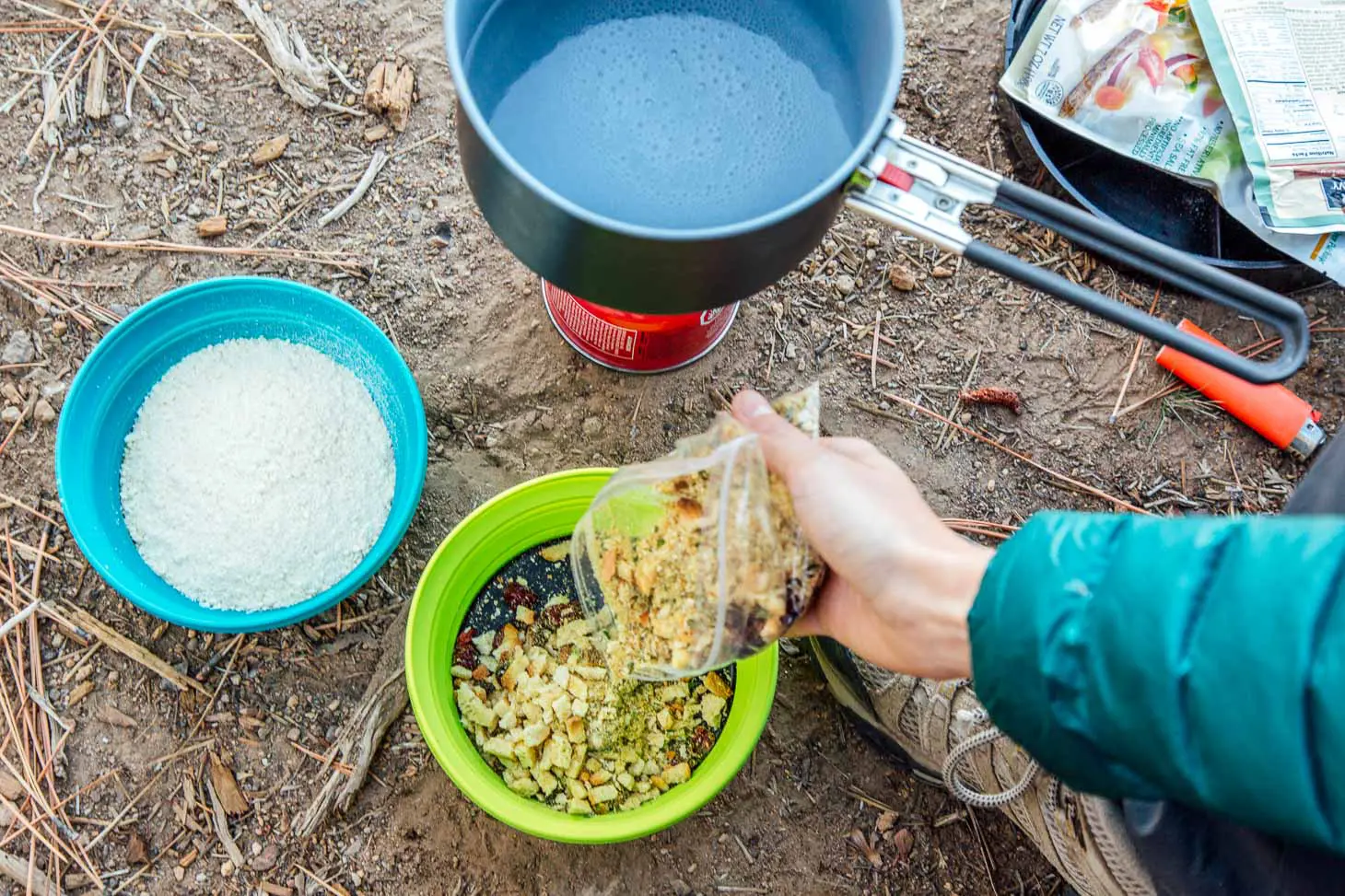 Megan pouring stuffing mix into a green bowl.