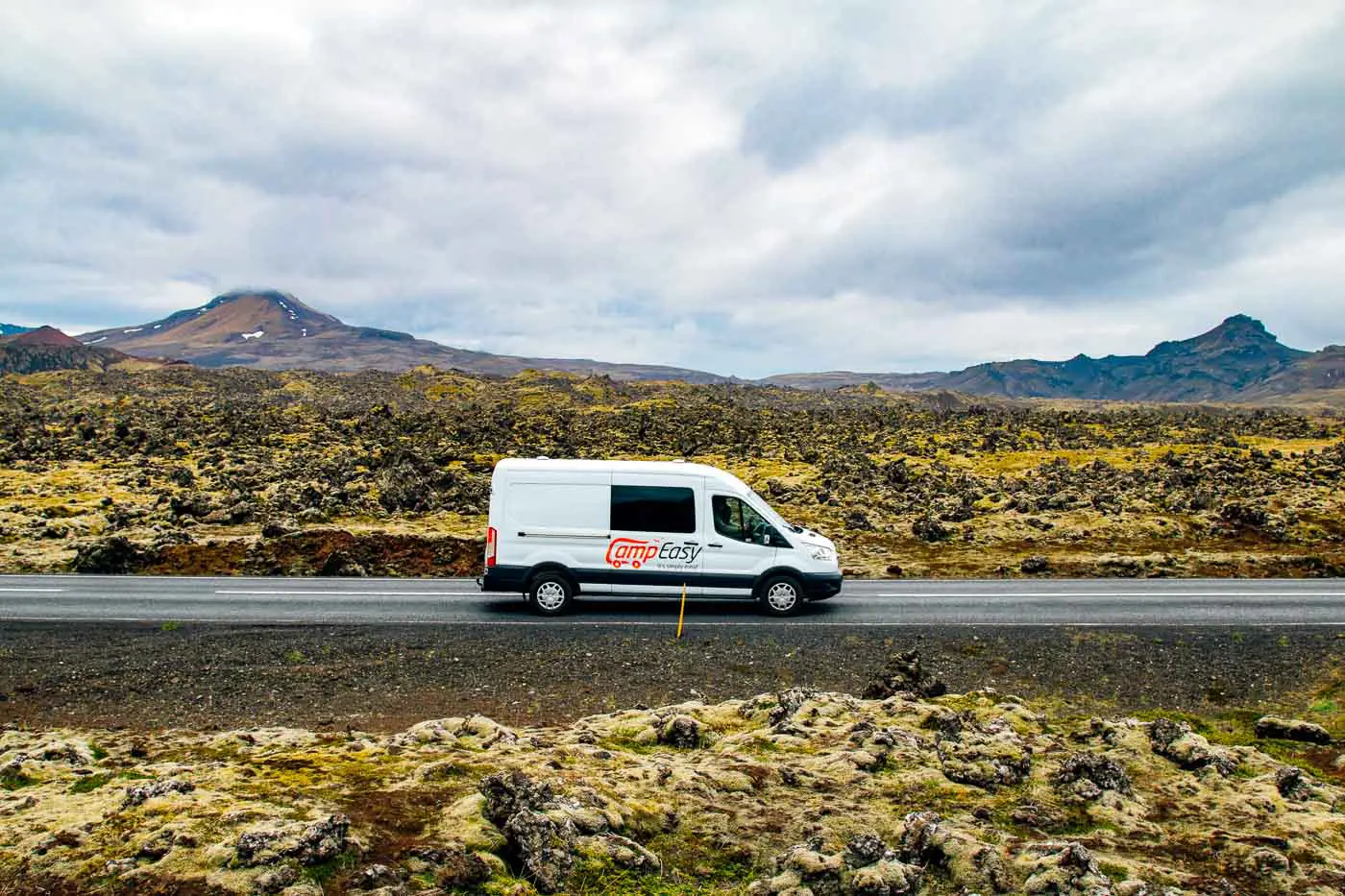 White camper van driving passed the Berserkjahraun Lava Fields in Iceland