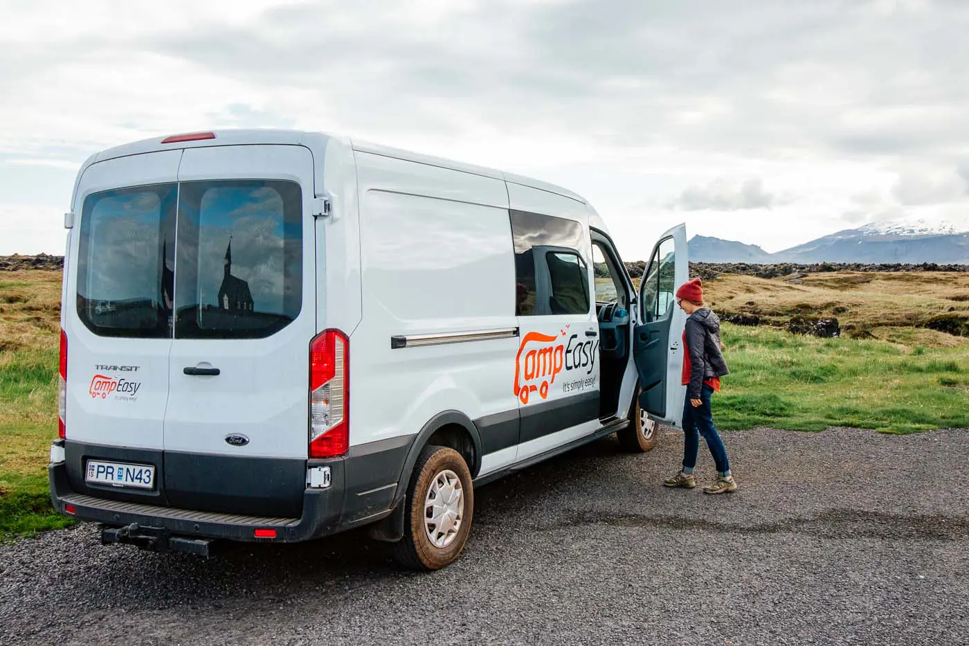 Woman opening the door of a Camp Easy camper van