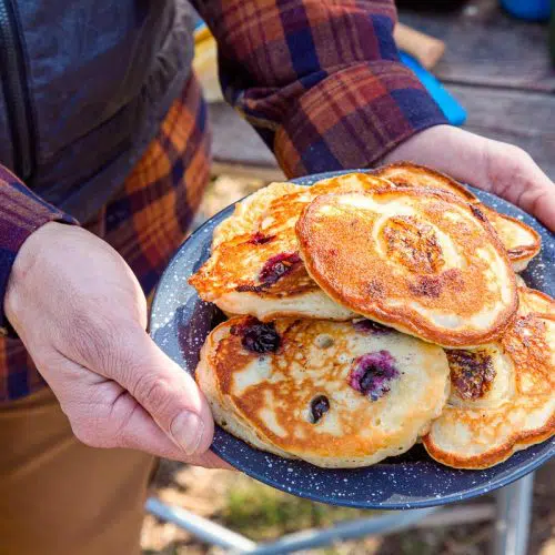 Michael holding a plate stacked with pancakes