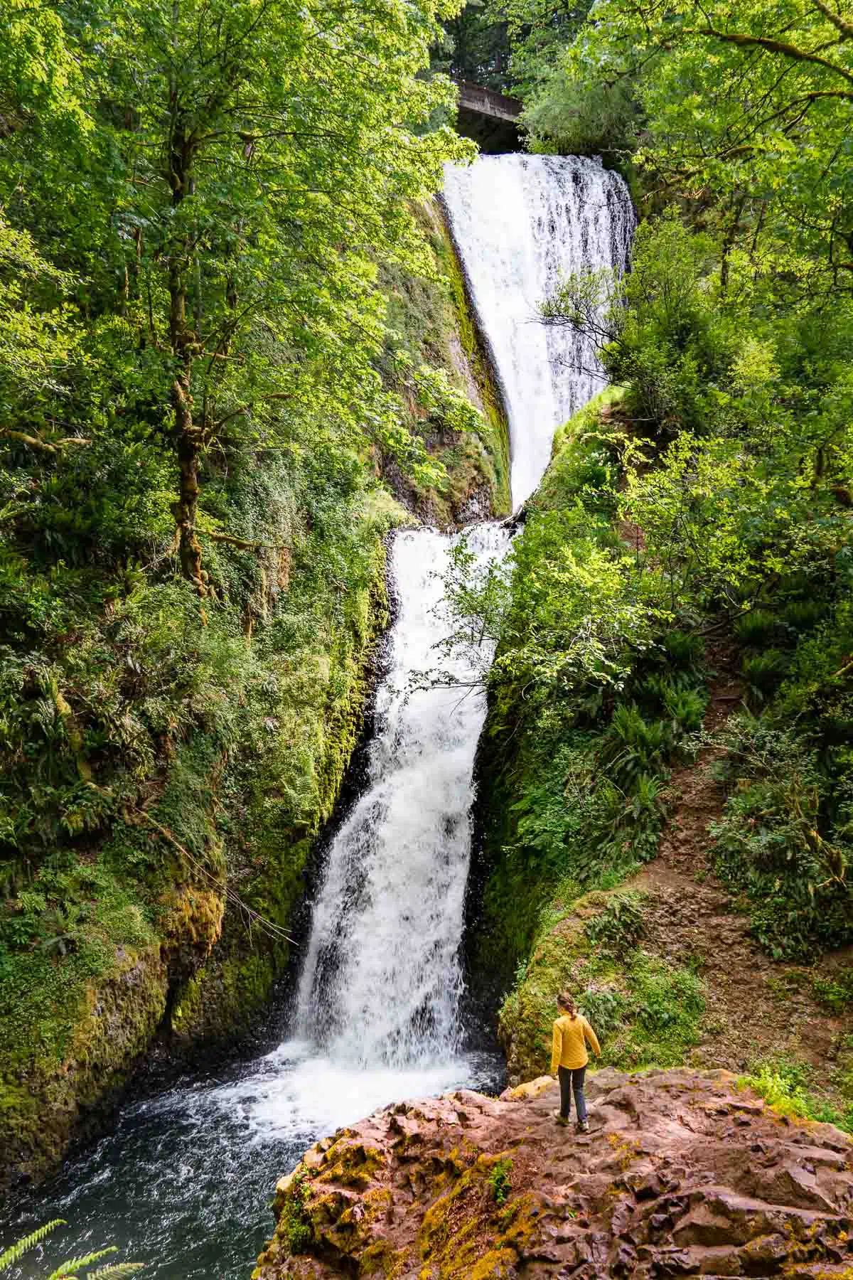 Megan standing on a large boulder in front of Bridal Veil Falls Oregon