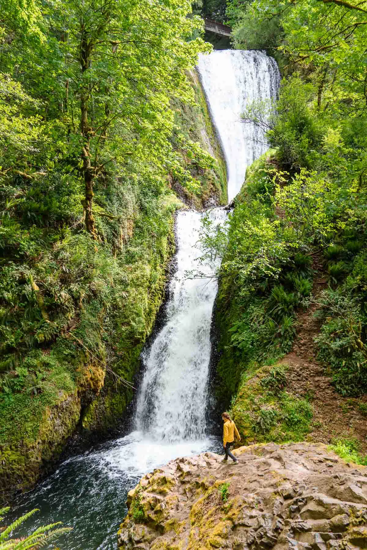 Megan standing on a large boulder in front of Bridal Veil Falls Oregon