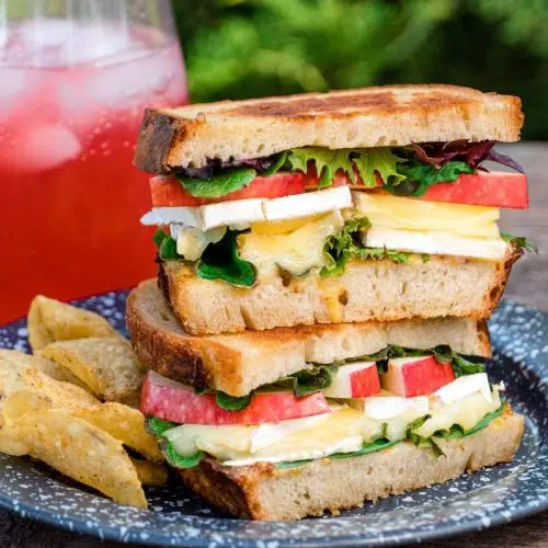 Grilled cheese sandwiches stacked on a blue plate