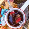 Two forks dipping strawberries into a bowl of chocolate fondue