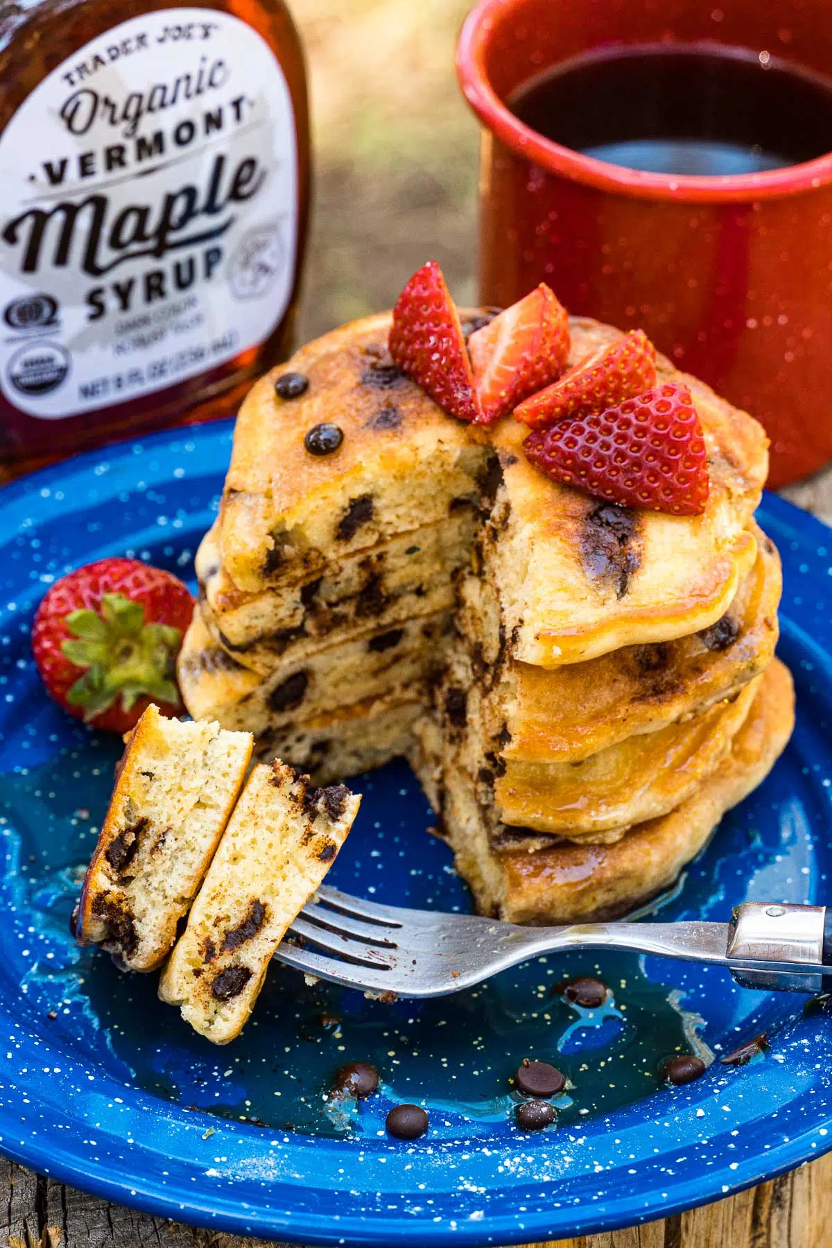 A stack of chocolate chip pancakes with strawberries on top