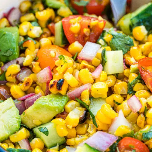 Corn salad with avocado, tomatoes, and cucumber