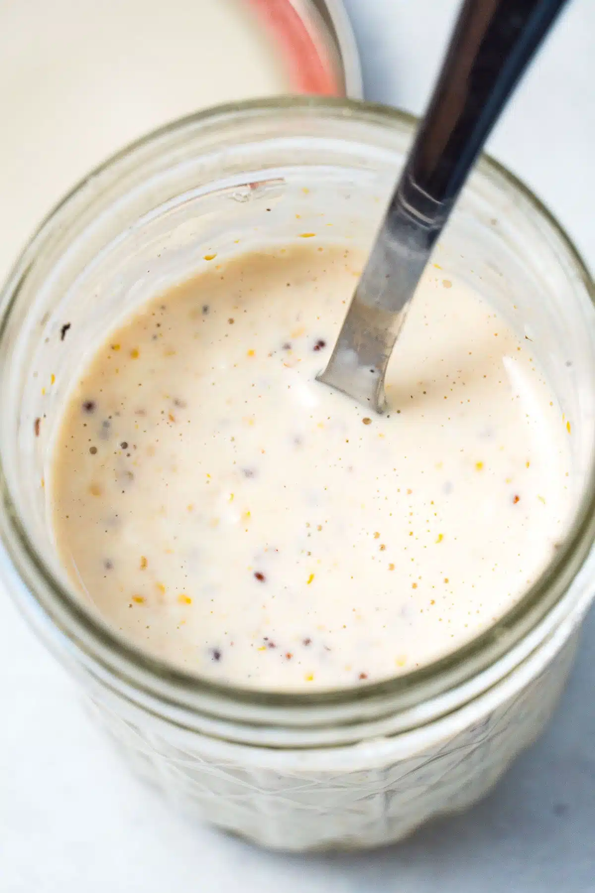 A mason jar filled with creamy coleslaw dressing.