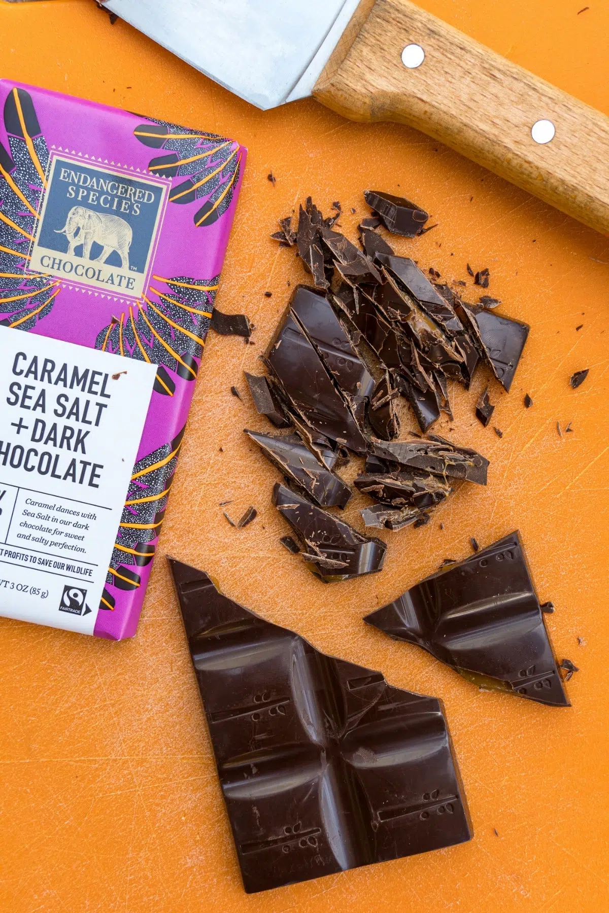 An Endangered Species Chocolate bar chopped on an orange cutting board