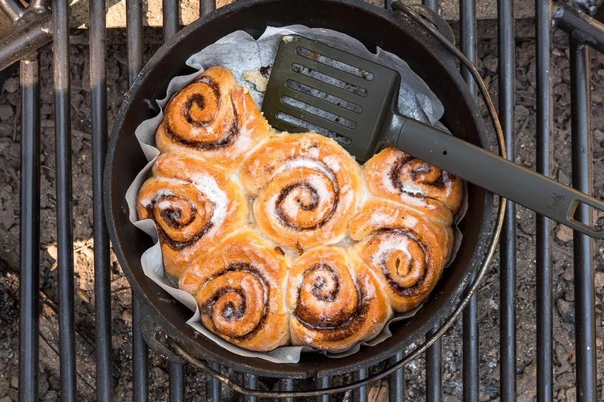 Cinnamon rolls in a dutch oven with a spatula