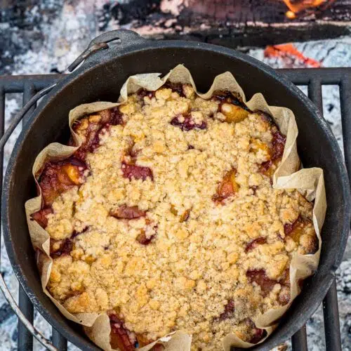 Peach cobbler in a Dutch oven over a campfire