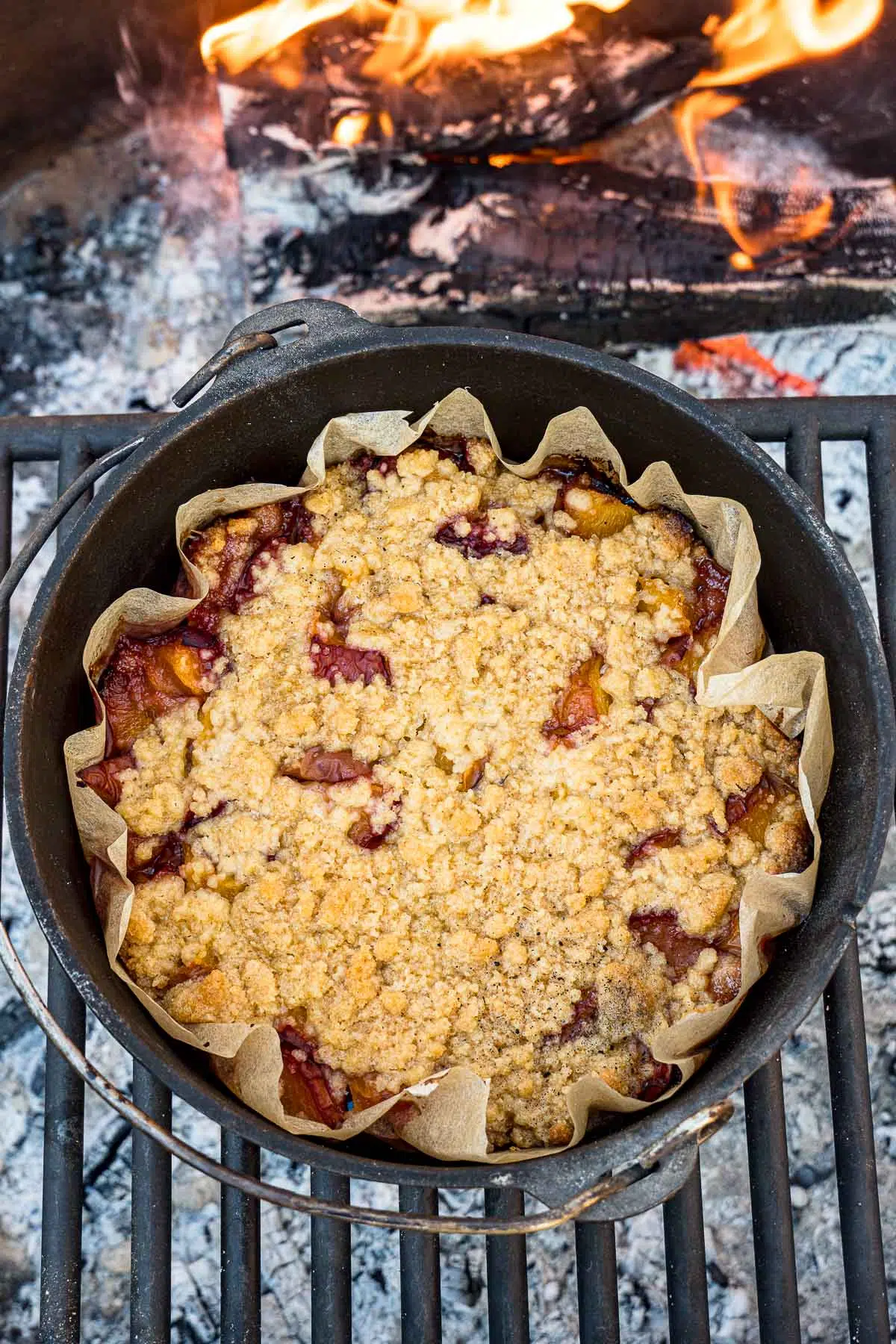 Peach cobbler in a Dutch oven over a campfire