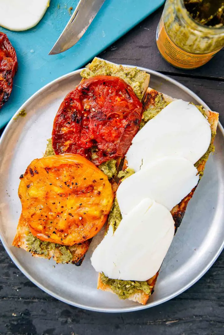 Grilled tomatoes and slices of cheese on a baguette