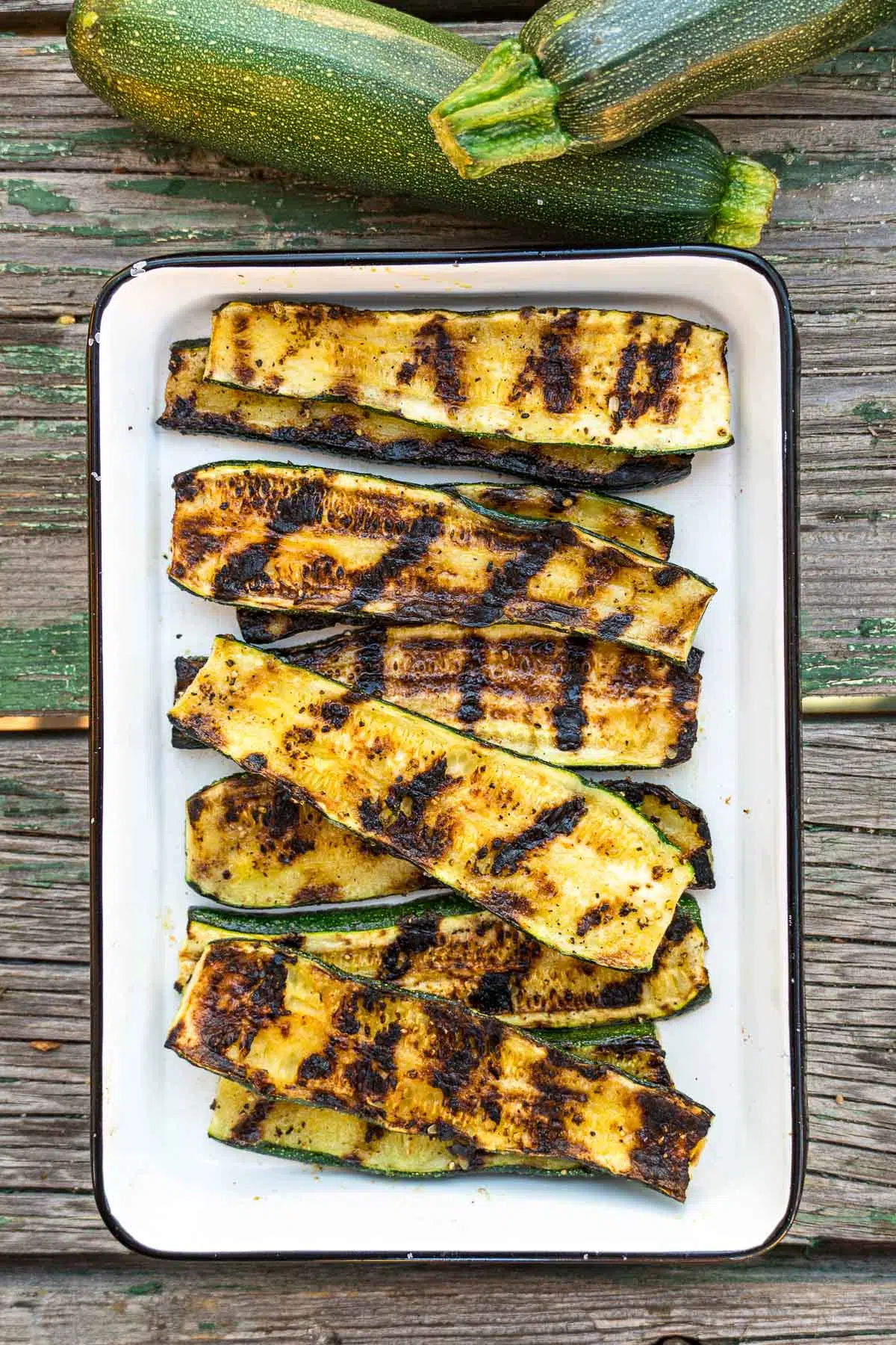 Grilled zucchini in a white enamel dish