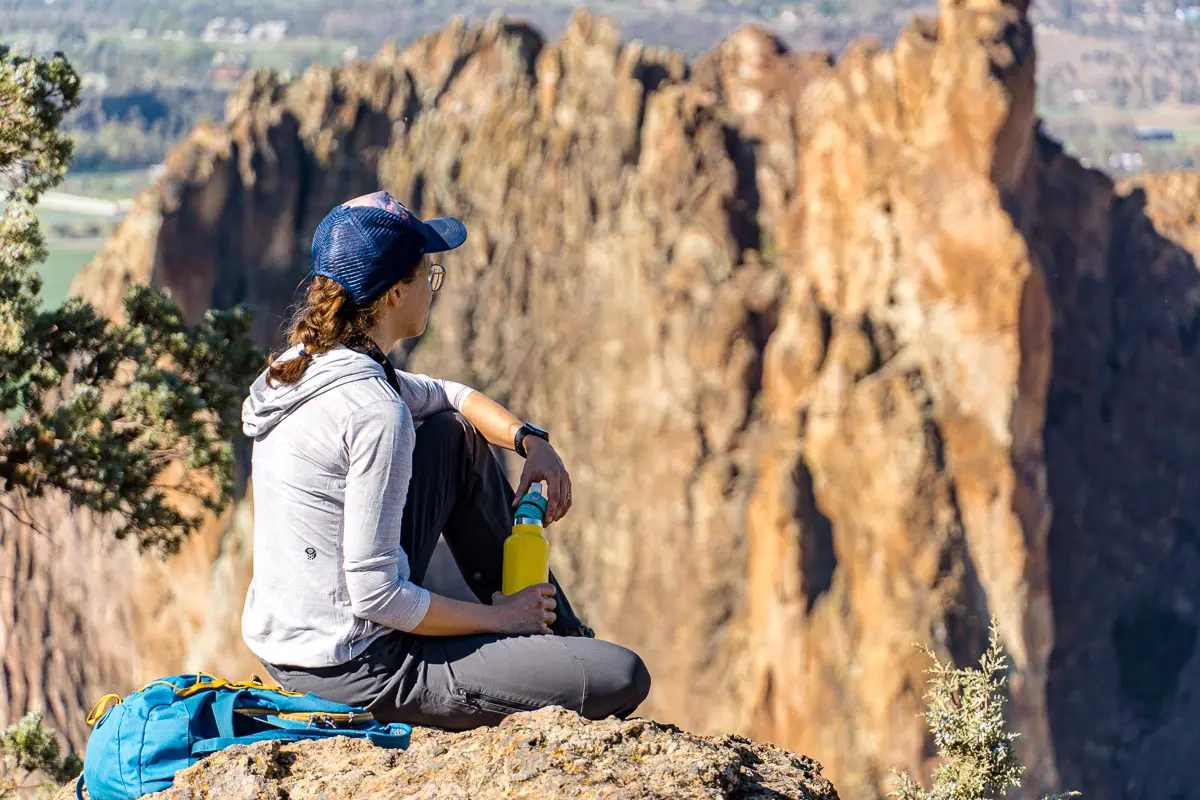 Megan is sitting on a rock and holding a water bottle.