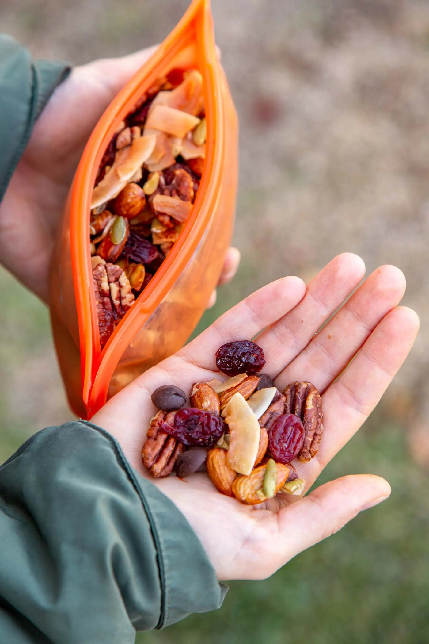 Megan holding an orange stasher bag and a handful of trail mix