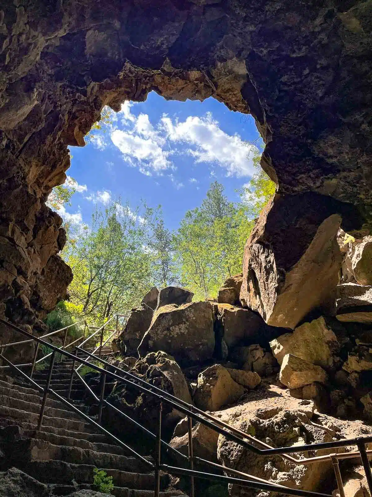 Looking out at the sky and trees from the entrance of the Lava River Cave