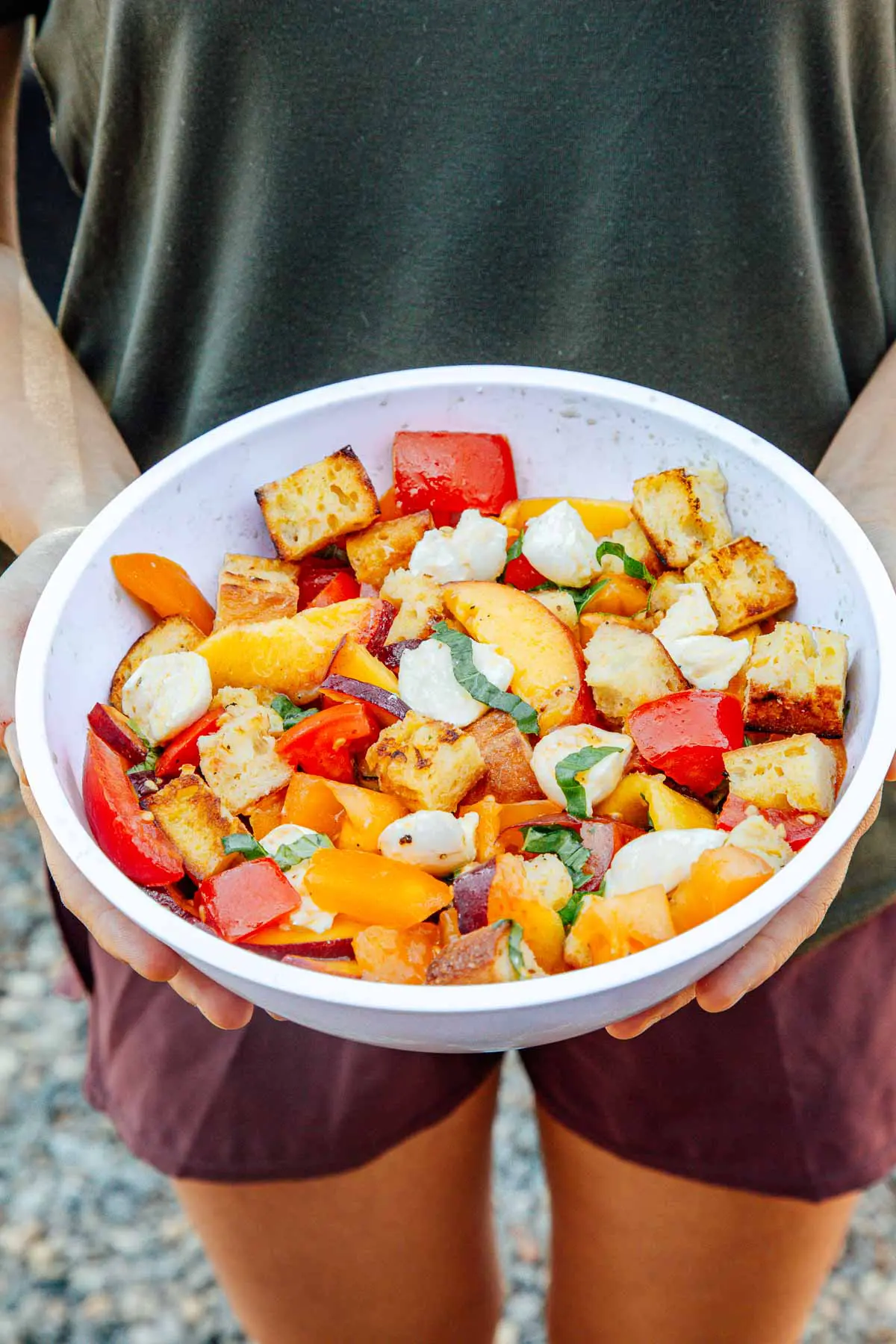 Megan presenting a white bowl full of panzanella