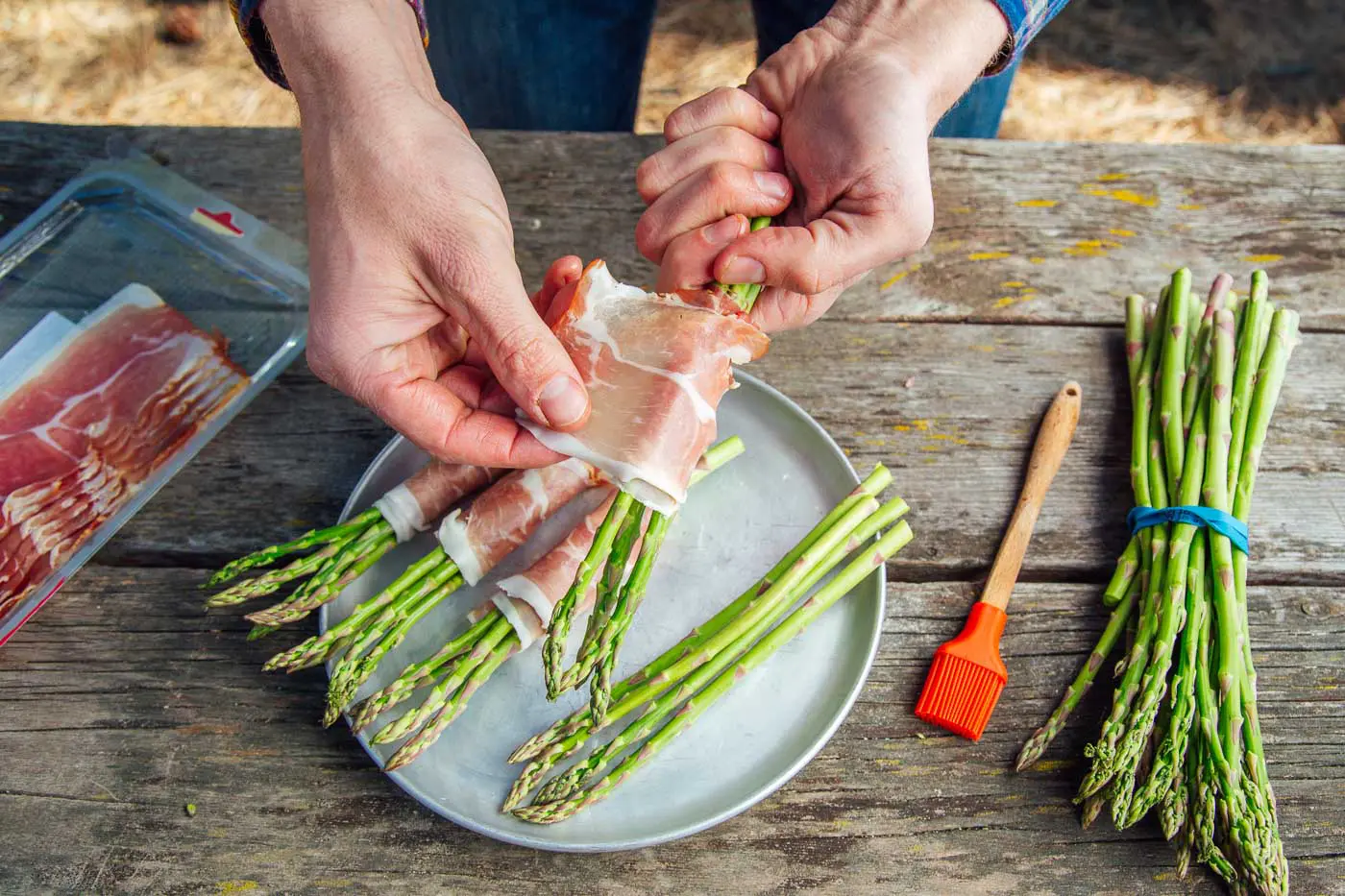 Michael wrapping prosciutto around asparagus stalks