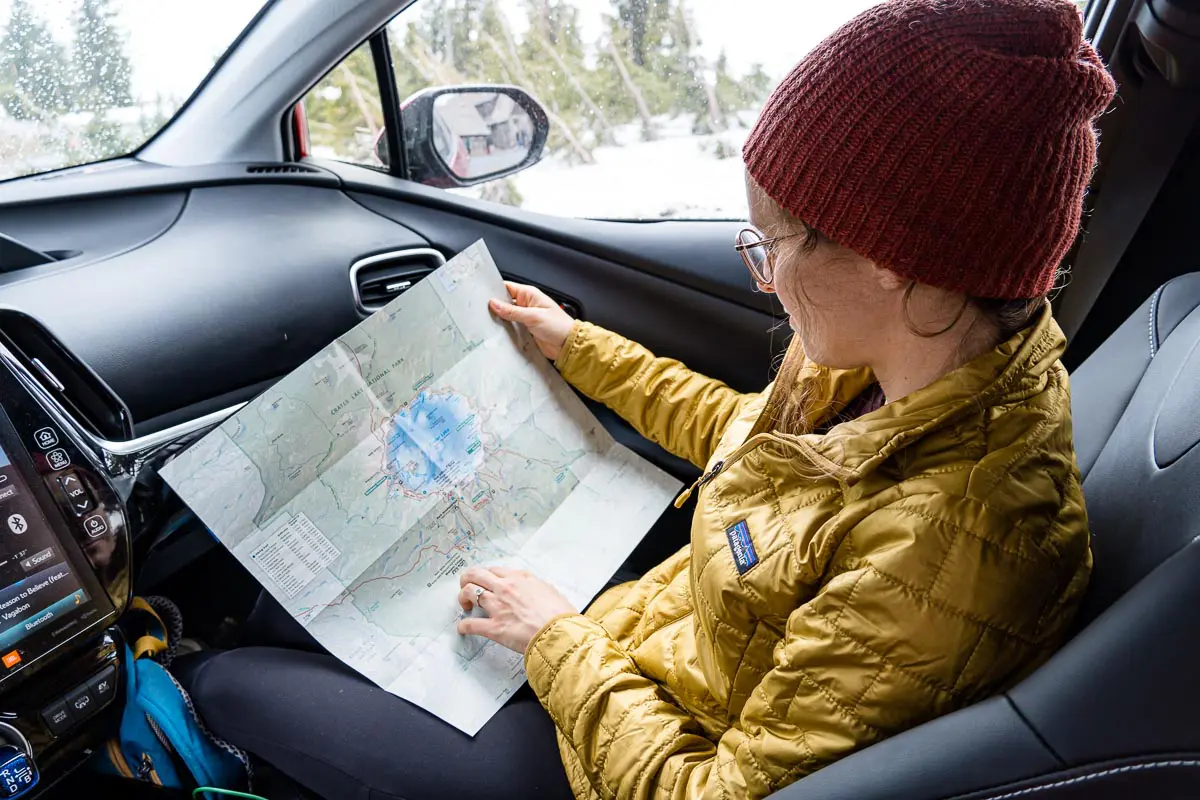 Megan is sitting in the front seat of a car looking at a map