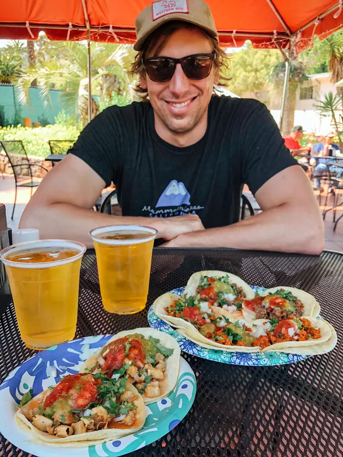 Smiling man sitting in front of a plate of tacos