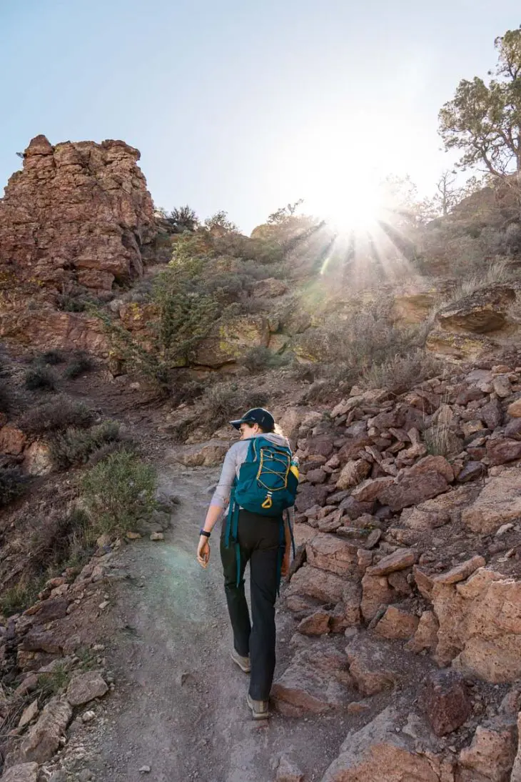 Megan hiking up a steep and rocky trail.