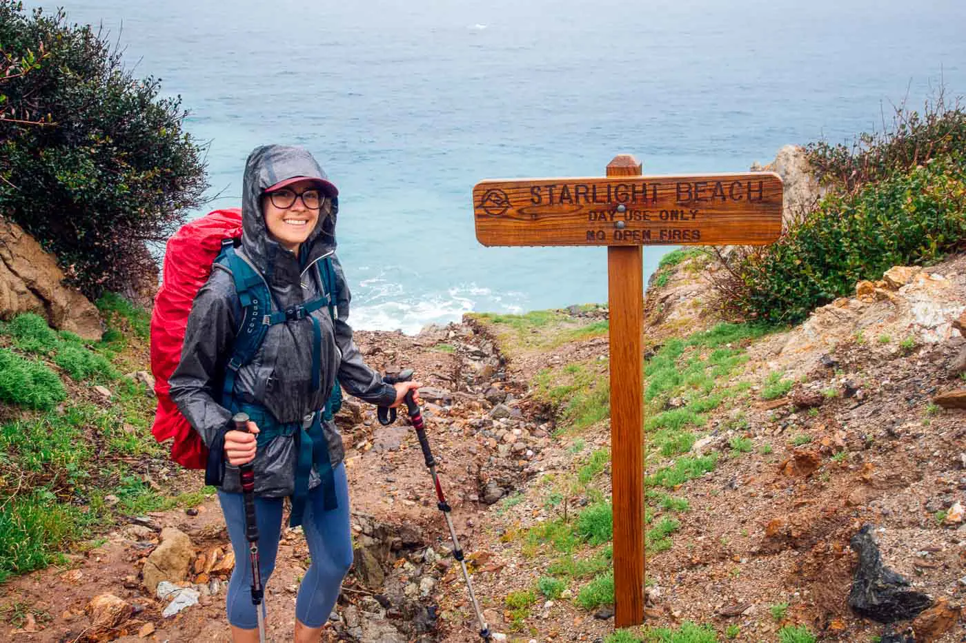 Woman standing in front of a wooden sign that reads "Starlight Beach".